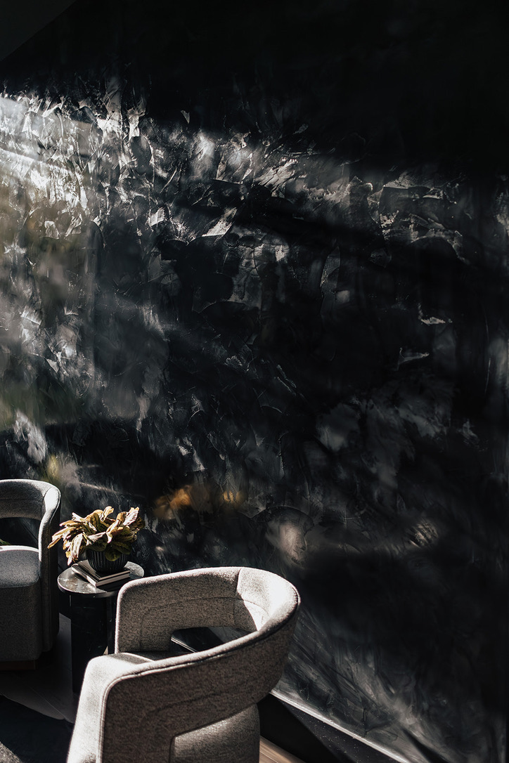 Black Venetian plaster lounge wall with natural light